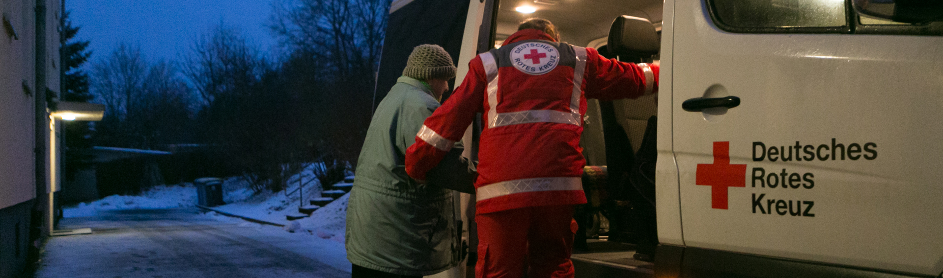 Mitarbeiter hilft Mann in RTW