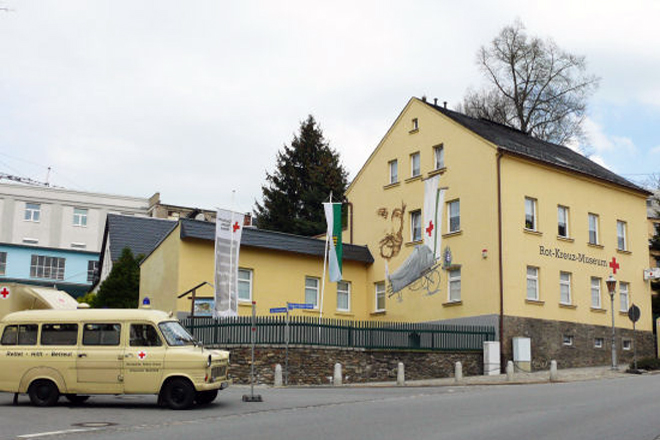 Blick auf das Gebäude des Sächsischen Rotkreuz-Museums, im Vordergrund eine Oldtimer Krankenwagen