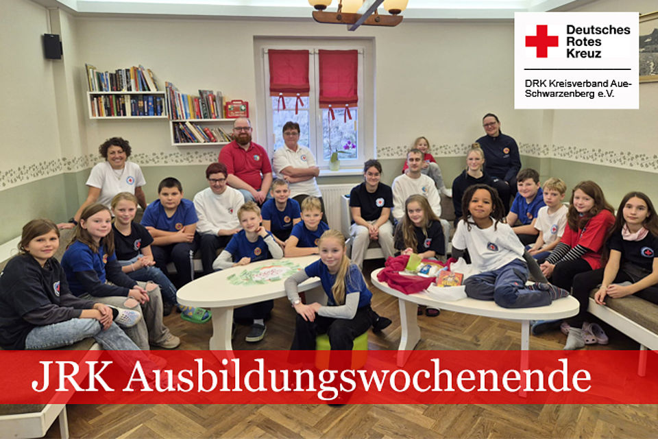 660_2025_JRK_AWE_Herbst_1.jpg JRK Ausbildungswochenende: Gruppenfoto im Aufenthaltsraum, alle Teilnehmer sitzen im Raum verteilt auf Tischen und Stühlen.