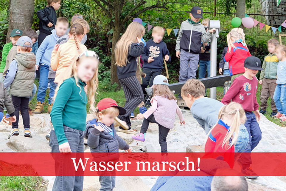 Kinder spielen im Freien an einen Wasserlauf.