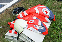 DRK Einsatzjacken und Helme liegen im Gras.