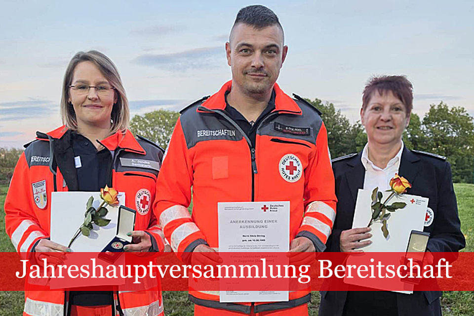 Drei Kameradinnen und Kameraden in DRK Einsatzkleidung nach erfolgter Ehrung