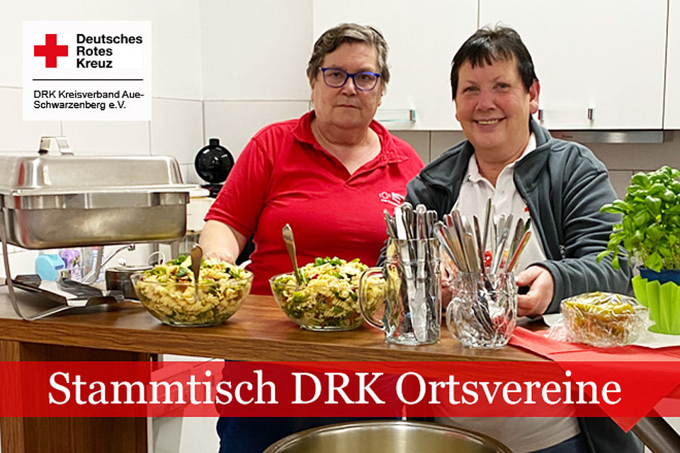 660_2026_Stammtisch_1.jpg Stammtisch DRK-Ortsvereine: Zwei Frauen in DRK Kleidung stehen hinter einem Tresen mit zubereiteten Speisen