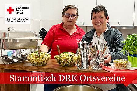Stammtisch DRK-Ortsvereine: Zwei Frauen in DRK Kleidung stehen hinter einem Tresen mit zubereiteten Speisen
