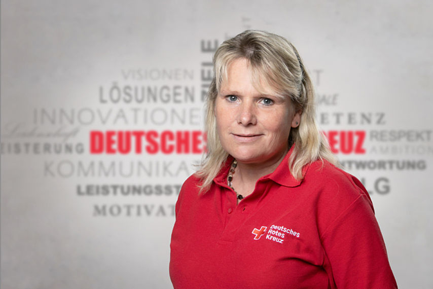 Mitarbeiterfoto mit Rotkreuz-Hintergrund