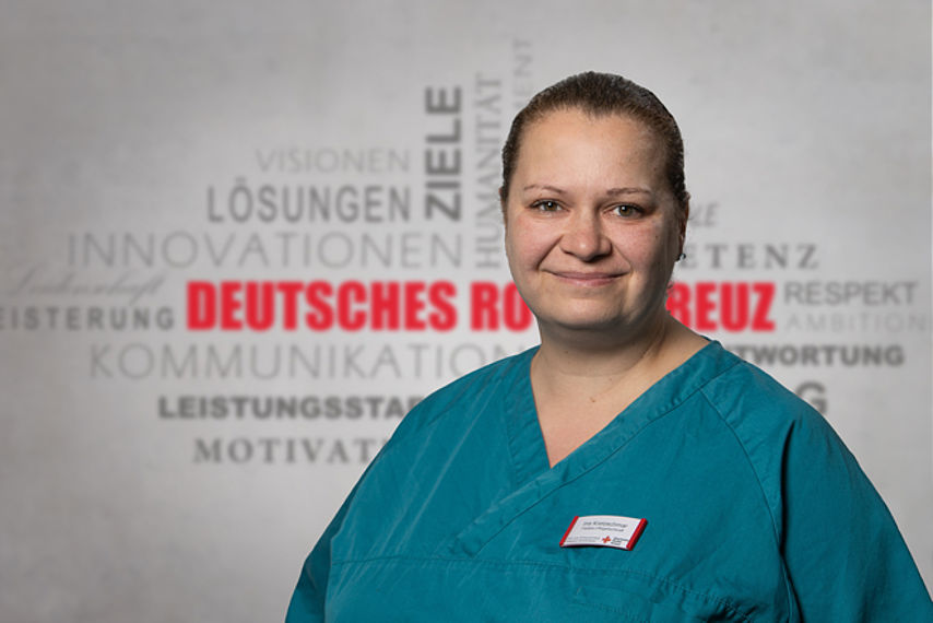 Mitarbeiterfoto mit Rotkreuz-Hintergrund