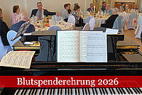 Blutspenderehrung 2026: Blick über einen Klavierflügel mit aufgestellten Noten in einen festlich geschmückten Veranstaltungsraum.