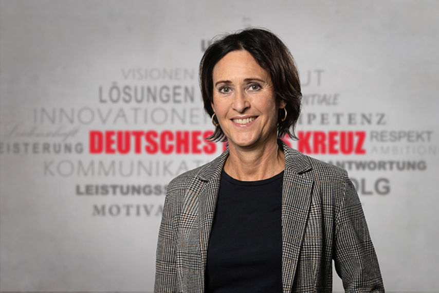Uta Georgi Mitarbeiterfoto mit Rotkreuz-Hintergrund