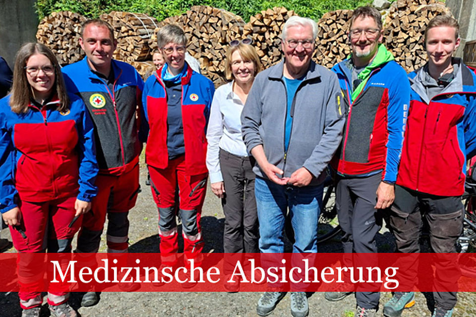 Bundespräsident Frank-Walter Steinmeier und dessen Frau Elke Büdenbender stehen neben Angehörigen der Bergwacht.