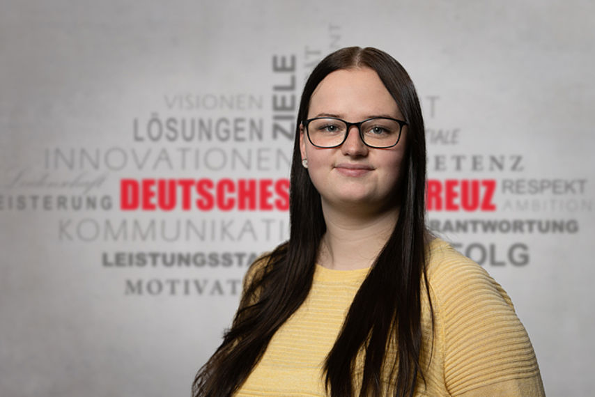 Mitarbeiterfoto mit Rotkreuz-Hintergrund