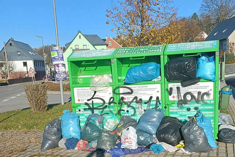 Drei überfüllte grüne DRK Altkleidercontainer mit zusätzlich abgelegten Müllsäcken davor