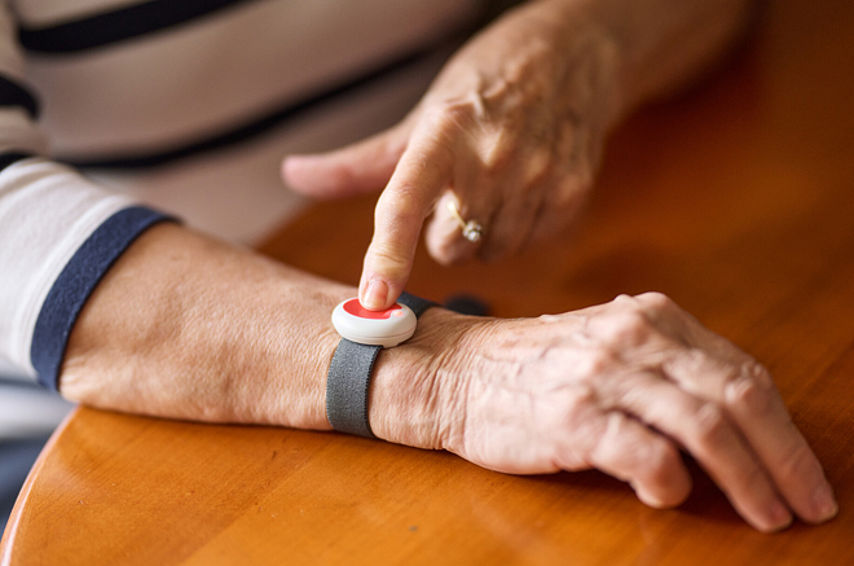 Hausnotrufknopf am Arm einer Seniorin