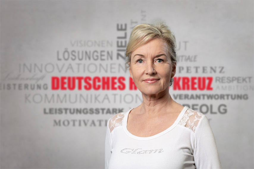 Mitarbeiterfoto mit Rotkreuz-Hintergrund