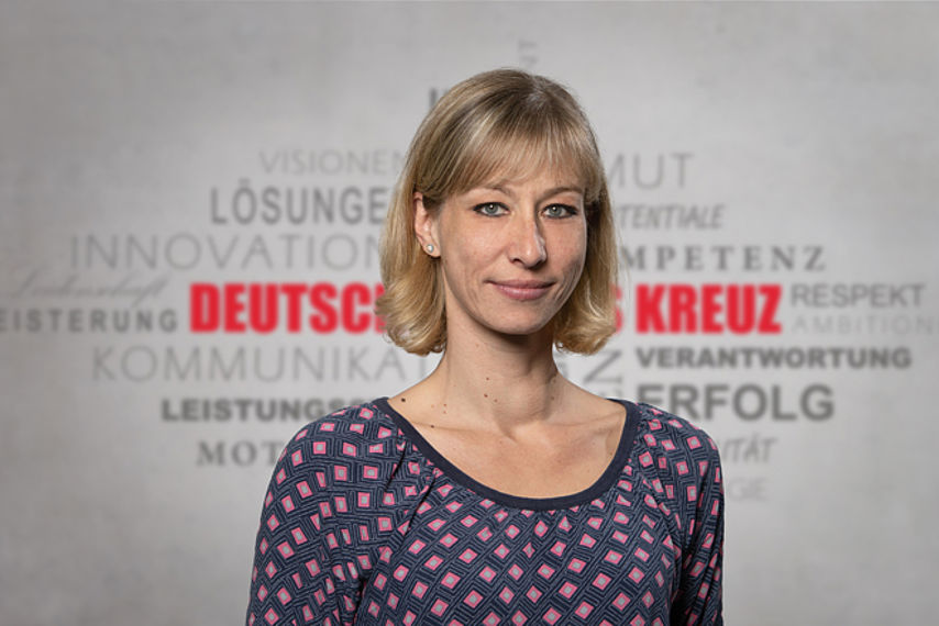 Mitarbeiterfoto mit Rotkreuz-Hintergrund