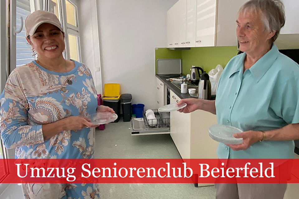 660_2026_Umzug_Seniorenclub_2.jpg Zwei Frauen stehen in einer hellen Küche und reichen sich Geschirr zu.