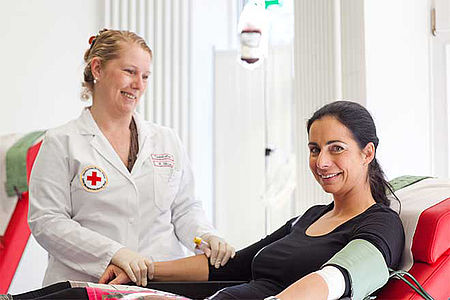 DRK Mitarbeiterin und Blutspenderin bei der Blutentnahme