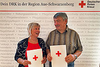 Ehrepaar vor DRK Fotowand mit Urkunde zur Blutspenderehrung