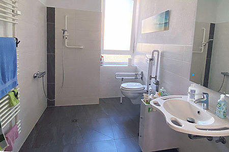 Gemeinschaftsbad mit unterfahrbarem Waschbecken und Dusche