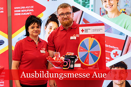 Ein Mann und eine Frau stehen in DRK Kleidung vor einem Messestand.