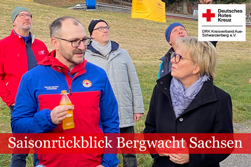im Vordergrund des Bildes ist Hannes Markert in Bergwachtkleidung im Gespräch mit Sachsens Tourismusministerin Barbara Klepsch