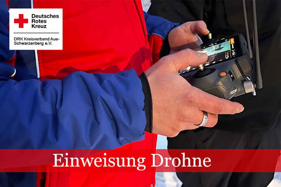 Angehöriger der Bergwacht hält Bedienelement einer Drohnen in der Hand