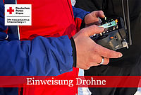 Angehöriger der Bergwacht hält Bedienelement einer Drohnen in der Hand