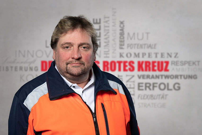 Heiko Meissner Mitarbeiterfoto mit Rotkreuz-Hintergrund